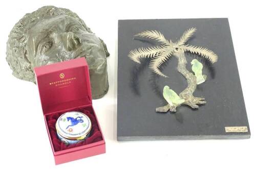 A collection of items, to include a fibreglass mask, a black slate plaque embellished with a silver coloured metal palm tree and two green carved birds and a Staffordshire enamel box and cover made to commemorate the 100th Anniversary of the Royal Tournam