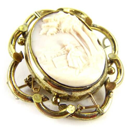 A swivel cameo brooch, the central oval panel depicting lady and tress in village scene, with a portrait back, in gilt metal frame, heavily rubbed, with single pin back and safety chain, 5cm x 5.5cm, in Elkington and Co Limited Court Jewellers 25 Regents