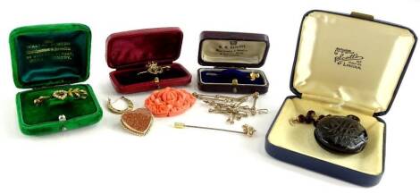 Various late 19th/early 20thC jewellery, to include a gold and seed pearl set heart shaped bar brooch, in Walter Burton box, a 9ct gold butterfly stickpin, on steel pin, a coral pendant on gilt metal chain, an imitation jet locket, a red stone set crucifi