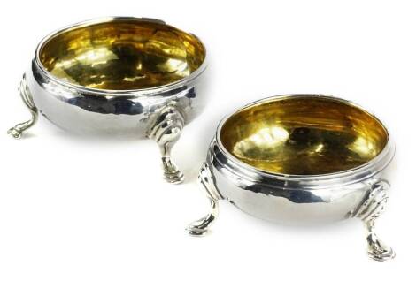 A pair of early 19thC silver circular open salts, each with a silver gilt interior on three shaped feet, marks indistinct, London assay, 2½oz.