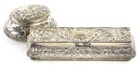 A 19thC Continental oval silver pill box, embossed with scrolls, putti, etc., London import marks for 1895, and a similar rectangular box. (AF)