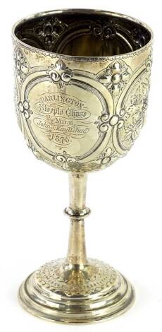 A Victorian silver goblet, with embossed decoration of flowers and leaves within oval cartouches, engraving Darlington Steeple chase ¾ mile J Kay 1875, marks indistinct, Birmingham assay, possible George Unite, 7¼oz, 19cm H.