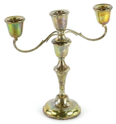 An Elizabeth II three branch silver candelabra, loaded, Birmingham 1959, (AF), 24cm H.