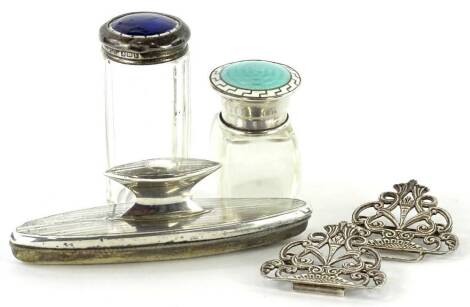 Three silver mounted items, to include a scent bottle and a jar, with enamel decoration, a nail buffer and a pierced silver nurses type buckle. (4)