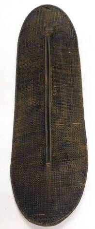 An African woven tribal shield from the Congo, probably Ngandu, with central handle, 141cm x 42cm.