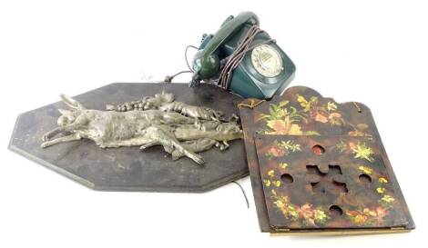 A vintage green plastic telephone, a wall mounted silvered metal plaque depicting dead game, fish etc. and a papier mache letter rack, decorated with flowers on a simulated tortoise shell ground.