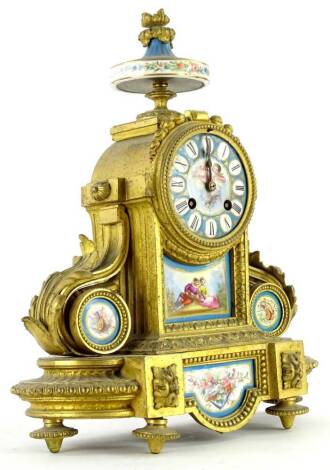 A late 19thC French gilt metal and porcelain mantel clock, the case with an urn to the top, the dial decorated with a putto and with Roman numerals, flanked by foliate scrolls, supported with roundels of musical trophies, on a shaped base, 35cm H.