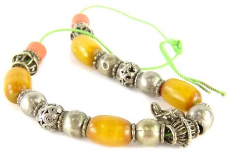 An Eastern necklace, with silver plated links, and butterscotch amber beads, on a green string strand.