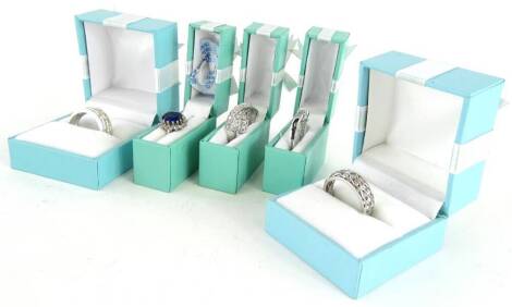 Five silver dress rings, each stone set with CZ stones, one with blue stone centre cluster design, boxed.