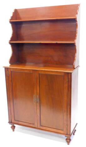 An early 19thC mahogany side cabinet, the top with two open shelves, each with shaped supports, the base with two panelled doors, on turned feet, 91cm W.