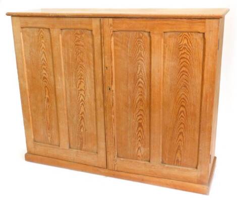 A Victorian pine cupboard, the top with a moulded edge above two panel doors, on plinth base, 153cm W.