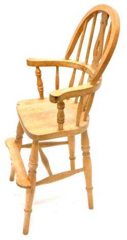 A beech child's Windsor high chair, with a pierced splat, solid seat on turned supports.