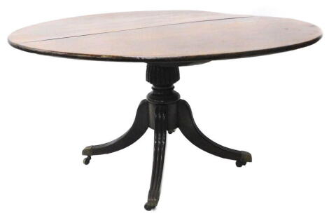 A George III mahogany dining table, the circular tilt top on a part fluted column and readed splayed legs with brass castors, 139cm dia, with associated table cloth.