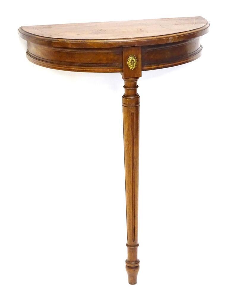 An Edwardian mahogany and tulipwood banded demi lune table, the top with a  moulded edge, above
