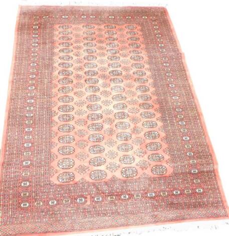 An Afghan type machine woven carpet, with four rows of medallions on a red ground with multiple borders, 267cm x 185cm.