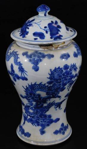 An 19thC Chinese blue and white baluster vase and cover, decorated with four claw celestial dragons (much damage around the rim), 32cm H.