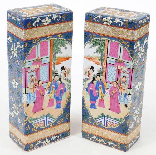 Two Chinese porcelain porcelain incense stick holders, of rectangular form decorated with mirror image panels of courtiers, before buildings and trees, pierced tops, polychrome decorated predominantly in orange, pink, blue and green enamels, 32cm H. (AF)