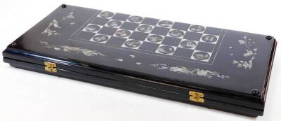 An Oriental design black lacquer and mother of pearl finish games box, of rectangular form, with chequer board exterior, and back gammon set to the interior, decorated with a mother of pearl finish of birds, scrolls, etc. when closed 5cm H x 62cm W x 29cm - 7