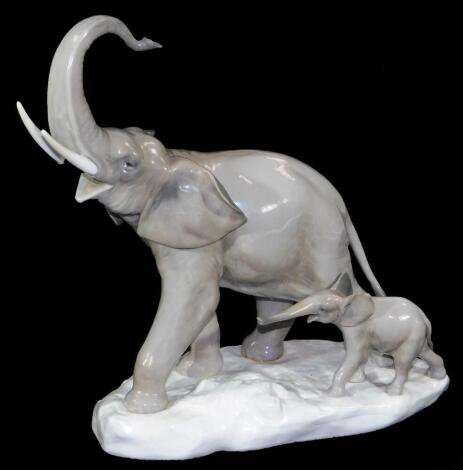 A 20thC Lladro figure of an elephant with calf, trunk raised, printed marks beneath, 31cm H.