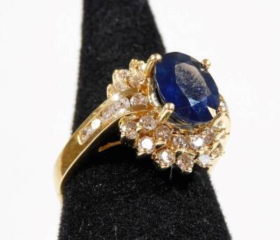 A sapphire and diamond dress ring, with central oval cut sapphire approx 2.69cts, in raised four claw setting, surrounded by two tiers of tiny round brilliant cut diamonds, the first with six stones to each side, the second with seven stones, in individua