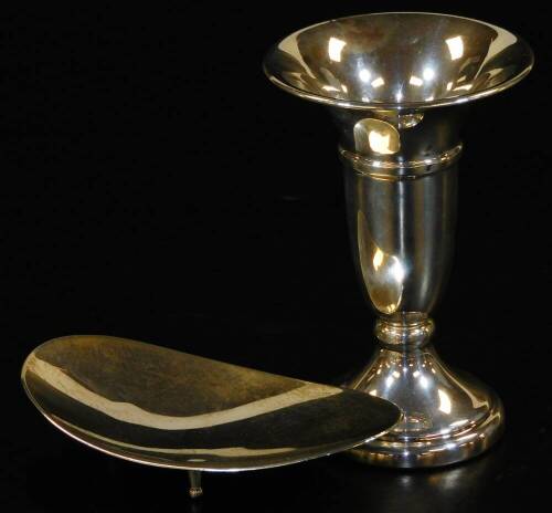 An Elizabeth II silver oval dish, makers Garrard & Co Ltd, of plain form, supported on three feet, 10cm L, 1.47oz, and a small silver vase with flared rim, on circular foot, Birmingham 1978, filled base, 9.5cm L. (2)