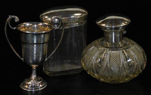 A George V silver two handled golf trophy, London 1935, (AF), 1.70oz, a cut glass scent bottle with silver hinged cap and mount, and a slice cut oval glass dressing table jar with silver lid, Birmingham 1898, 2.5oz weighable silver. (3)