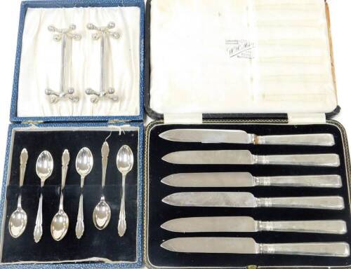 A pair of six silver handled tea knives, in case, a set of six George V silver coffee spoons, Sheffield 1934, in case, pair of silver knife rests, makers James Dixon & Sons, Sheffield 1958, 5.2oz total weighable silver.