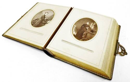 A Victorian black leather photograph album, with gilt coloured clasps, containing various photographs, black and white picture scenes, photographic portrait of a lady, 14cm x 10cm, various other photographs, children, soldiers, figure in pram, horse and c