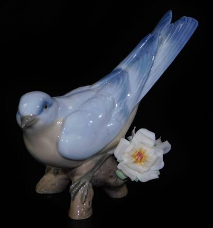 A Lladro figure group of a bird, on flowering tree branch, printed marks beneath, 10cm H.