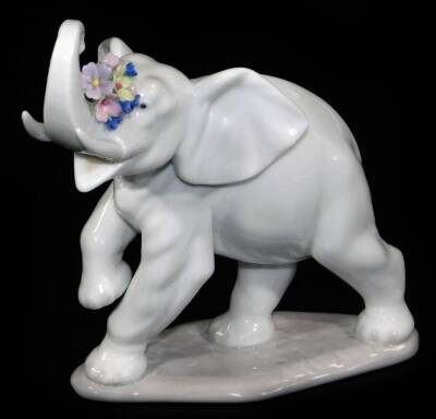 A Lladro figure of an elephant, with flowers to the trunk, no. 6461, printed and impressed marks beneath, 14cm H.