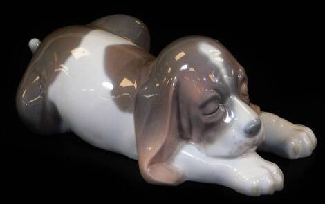 A Lladro figure of a sleeping Bassett hound, printed marks beneath, 6cm H.