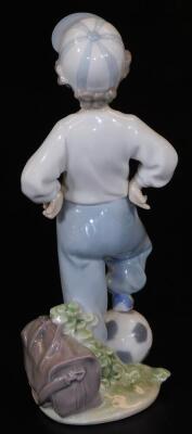 A Lladro figure of a boy, in cap with foot on football, printed marks beneath, 23cm H. - 2