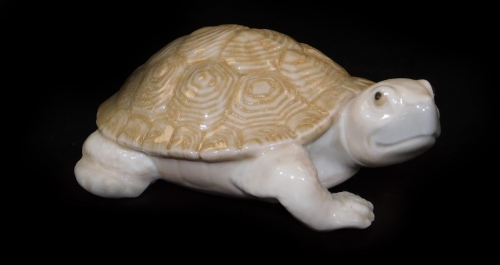 A Lladro figure of a turtle, on wooden base, printed marks beneath, 9cm W.