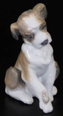 A Lladro figure of a puppy, with snail to the leg, printed marks beneath, 13cm H.