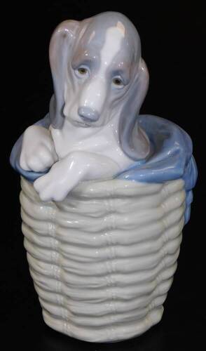 A Lladro figure of a puppy in basket, no. D30E, printed and impressed marks beneath, 20cm H.