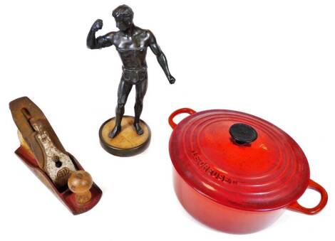 A spelter figure of a gladiator, in standing pose, on circular foot, a GTL wood plane and a Le Creuset casserole dish and cover in red, 28cm W. (3)