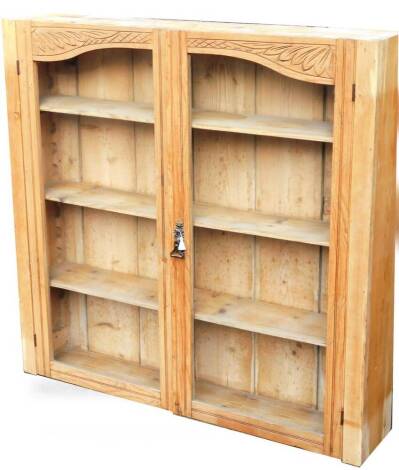 A pine hanging cupboard, of rectangular form, with two glazed doors, revealing fitted shelves, 109cm H, 110cm W, 23cm D.