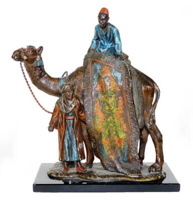 A cast and painted spelter figural table lighter, in the manner of Bergmann, formed as an Arabian rug seller on a camel's back, aside a further figure, on a rectangular base, 19cm H. (AF)