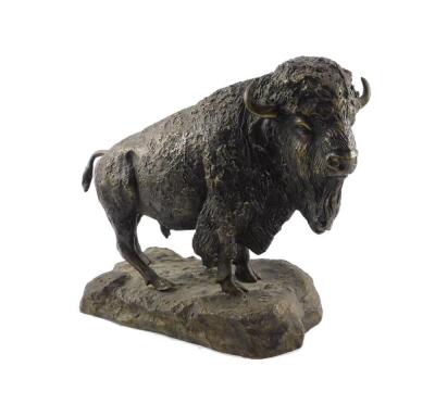 A bronze figure of a bison, modelled standing on a naturalistic base, bears signature, 29cm H, 36cm W, 14cm D.