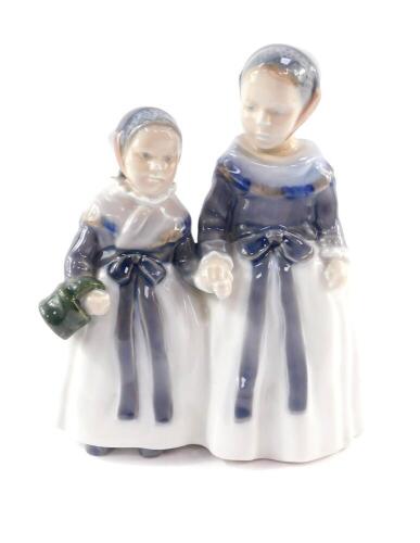 A Royal Copenhagen porcelain figure group of a pair of girls, holding hands, No 1316, printed and painted marks.