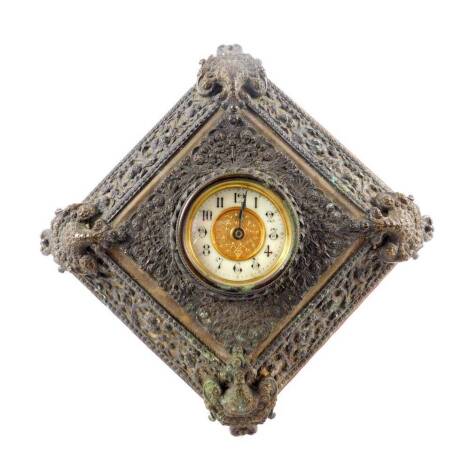 A late 19thC strut clock, The British United Clock Company Ltd, brass dial with enamel chapter ring bearing Arabic numerals, clockwork movement, the metal framed case carved with flowers and foliate scrolls, wooden backed, 22cm H, 22cm W.