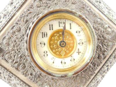 A late 19thC strut clock, The British United Clock Company Ltd, brass dial with enamel chapter ring bearing Arabic numerals, clockwork movement, the metal framed case carved with flowers and foliate scrolls, wooden backed, 22cm H, 22cm W. - 2