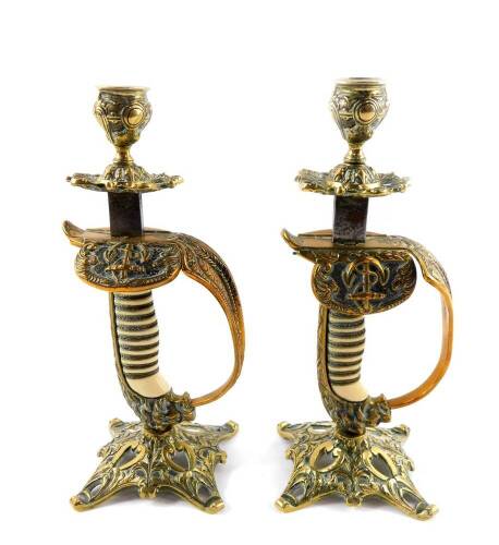 A pair of German WWI period naval sword hilt candlesticks, brass cast with wire bound grip and lion's head pommel, 24.5cm H.