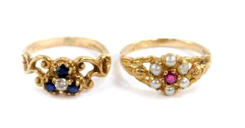 A 9ct gold ruby and seed pearl flower head ring, size K, together with a 9ct gold three stone sapphire and cubic zirconia set four stone ring, size J, 4.4g.