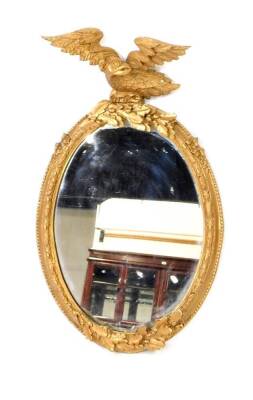 A Victorian oval gesso wall mirror, later gilt painted, with eagle surmount resting on acorns and oak leaves, the frame with floral decoration and beaded edging, and acorns and oak leaves to the bottom, 83cm H, 49.5cm W.
