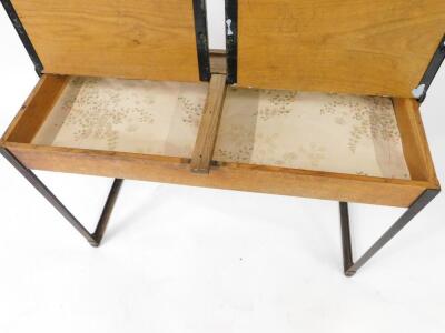 An early 20thC oak and cast iron framed child's double desk, with one long pen recess, two ink well recesses and two lift up lids, raised on straight metal supports, 61cm H, 92cm W, 38cm D. - 2