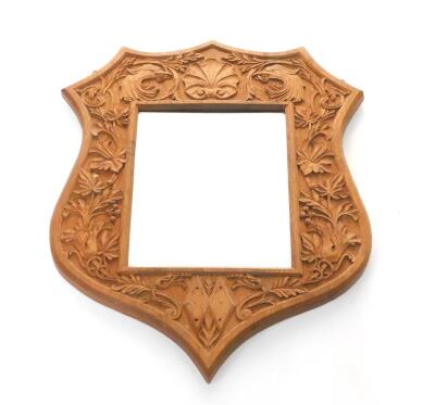 A Victorian oak shield shape wall mirror, rectangular set with bevelled glass, carved with beast's heads, flowers and foliate scrolls, 67cm H, 52cm W.