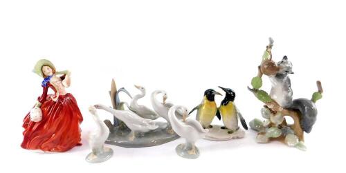 A Royal Doulton figure modelled as Autumn Breezes HN1934, Lladro porcelain figure of a squirrel with a nut, Lladro goose group and two single geese, and a Karl Ens porcelain figure of a pair of penguins. (6)