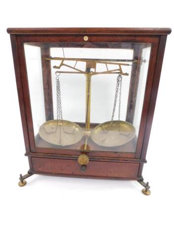 A set of 19thC balance scales by G Wolters, London, brass framed, glazed mahogany case, No.2, with frieze drawer opening to reveal weights and further scale accessories, raised on four adjustable brass screw feet, 41cm H, 37.5cm W, 24cm D.