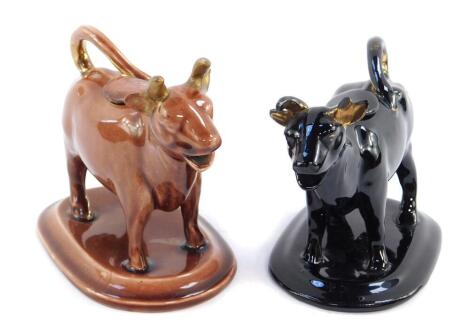 Two 19thC Jackfield pottery cow creamers, one in brown glaze, the other in black, gilt heightened, 16cm W. (AF)